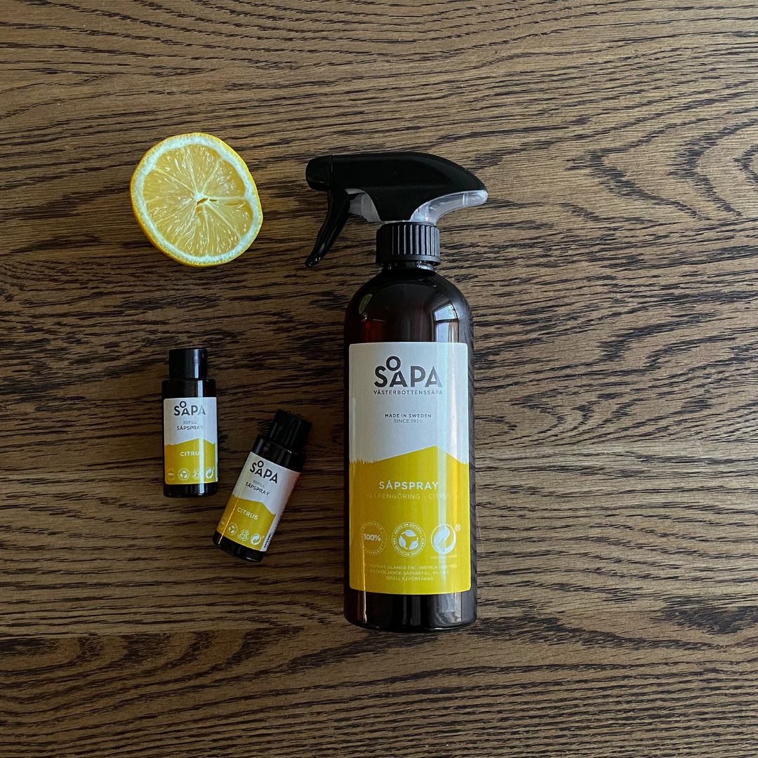 Mild, naturlig flytande såpa med frisk citrusdoft och två refiller som ligger på ett bord.