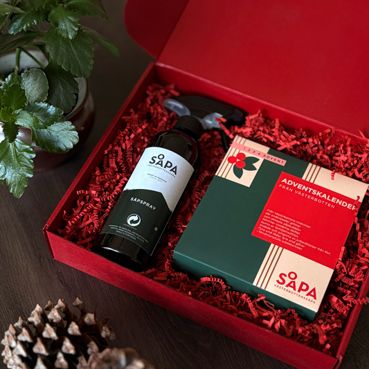 Västerbottenssåpas adventskalender i en öppen röd presentlåda med en såpsprayflaska och en adventsförpackning.