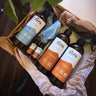 En öppen presentbox med Västerbottenssåpa städprodukter, inklusive fönsterputs, allrengöring och såpspray, samt trasor och refillflaskor.